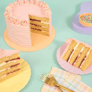 Vegan Vanilla Cake with four layers of moist vanilla sponge and pink vegan buttercream icing by Crumbs & Doilies.